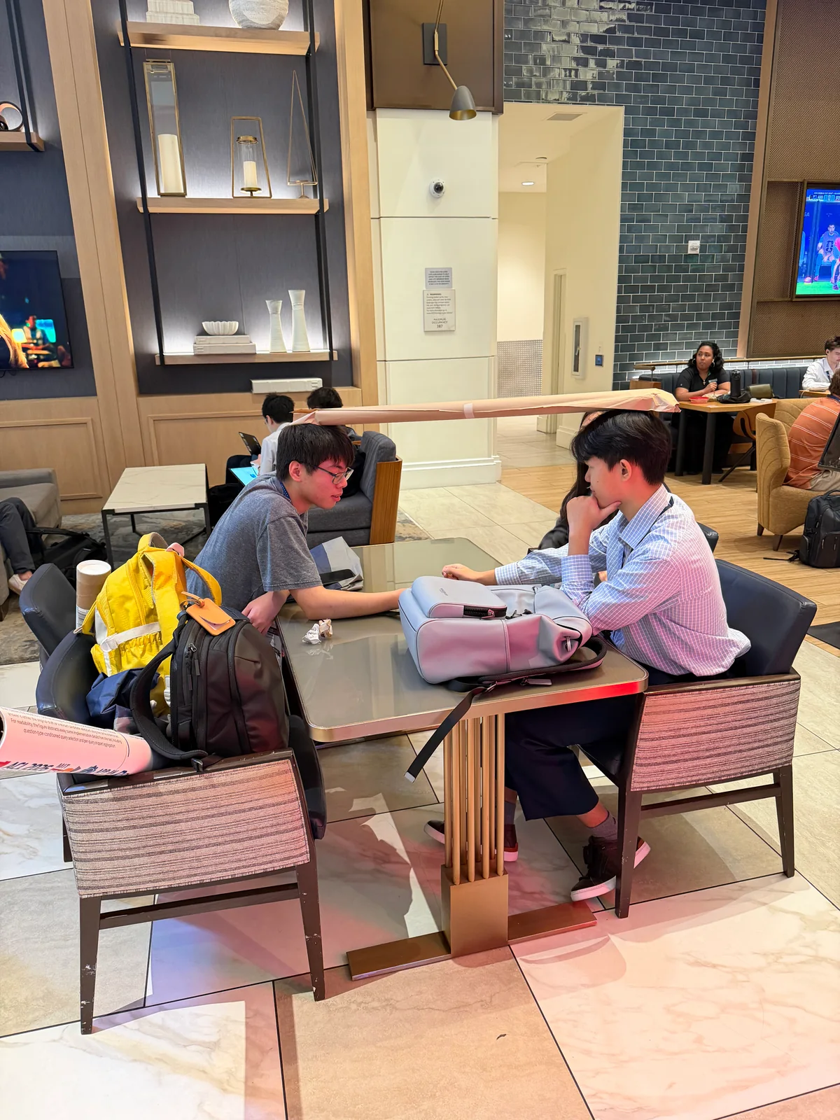 Two students in conversation around a table between conference sessions.