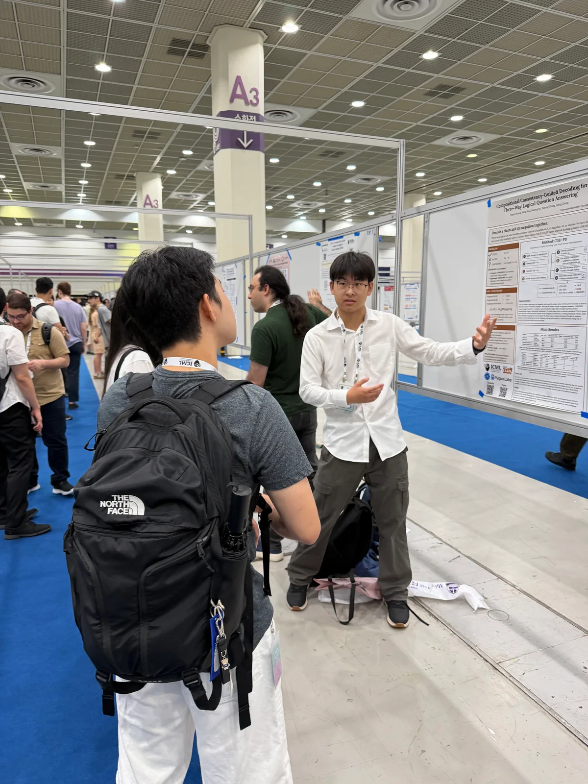 A student explaining a research poster to visitors at ICML.